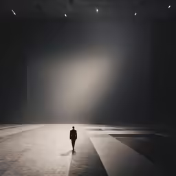 a man walking through a very large dark room