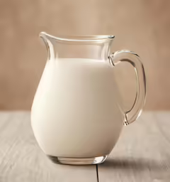 a glass pitcher of milk on the table