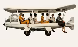 some people are sitting on a propellor that is being pulled by an airplane