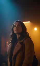 a woman is standing under some spotlights