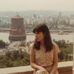 a woman sitting on top of a tall building