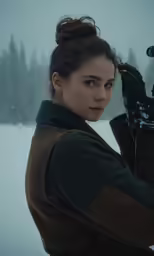 a woman holding a camera in the snow