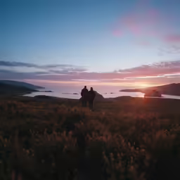 the two people are standing on top of the hill