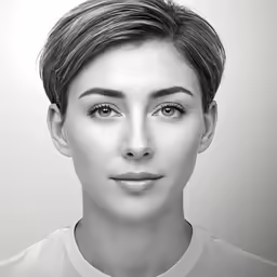 a woman with short hair and a tie is posing for a photo