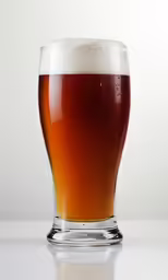 the beer is being poured into the glass