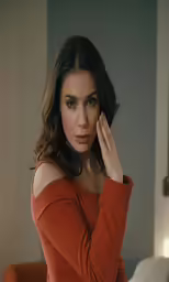 a close up of a person holding their hand near her ear