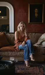 a woman sitting on top of a couch in a living room