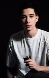a boy holding a cup in his right hand