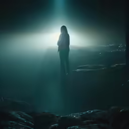 a person standing alone with their back lights on