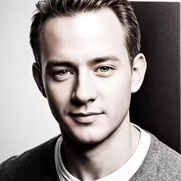 a young man with very short hair and an ugly smile