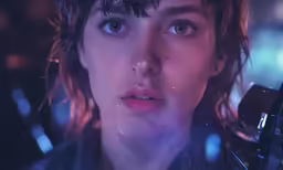 a close up view of an alien woman with blue eyes