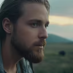 there is a man with a full beard staring into the distance