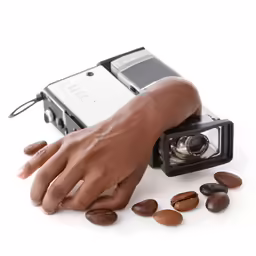 a hand with a camera next to nuts