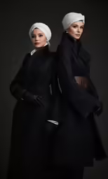 two women with turbans are posed in full robes
