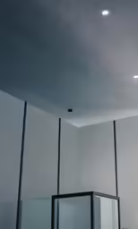 an empty room with glass and a few black rectangular objects