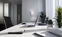 an empty conference table has two laptops on it