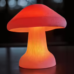 a mushroom shaped light is lit up on a table