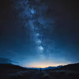 the dark, silhouette of a person standing on a dirt road at night