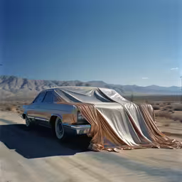 there is a car with a covered covering on the side of it,an abandoned cadillac in the desert with cover over