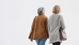 two women are walking towards the distance
