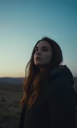 a woman standing on the ground with her head turned to the right