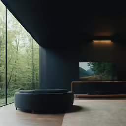 an empty living room with a circular couch and large windows