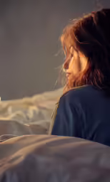 a woman is sleeping in bed next to an alarm clock