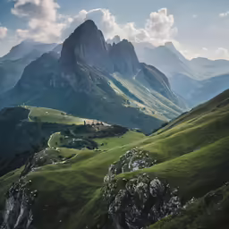 a mountain with grassy green hills and houses on them