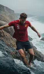 the young man is playing in the water near the rocks