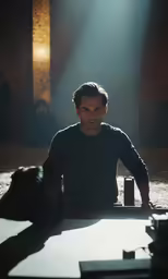a man sitting at a table with two cans