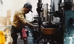a man working with a machine in an industrial area
