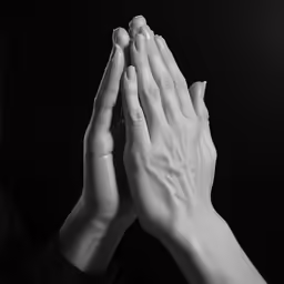 a black and white photo of two hands holding each other