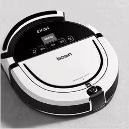 a white and black robot sitting on top of a gray surface