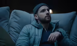 a man sits on the couch and looks at something