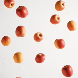 multiple apples being thrown to the side of the image