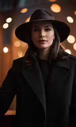 a woman in black clothes wearing a brown hat