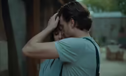 the man is holding his head near his shoulder