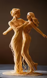 two figurines are displayed as one has her arms around the other