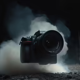 a camera is surrounded by white smoke from the ground