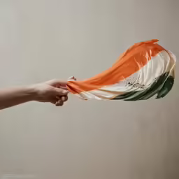 a woman holding an indian flag in her hand