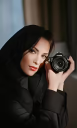 a woman is posing for a picture with a camera