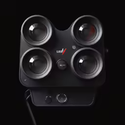 four camera lens mounted on a black wall