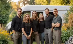 a family is posing for a photo in front of a bus