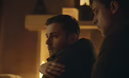 three people standing together in a dark room