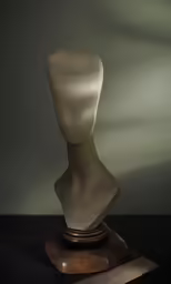 a sculpture in front of a window with a spotlight shining on it