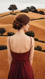 there is a woman wearing a dress standing in the grass
