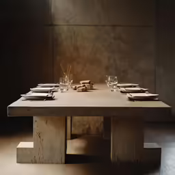 a long dining table with candles and dinner ware on the table