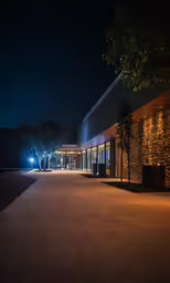 a dark, empty walkway leads to a restaurant with a large window