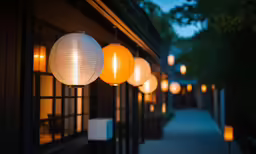 several different paper lanterns hanging from the front of a building