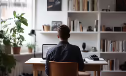 there is a man sitting in a chair working on a computer